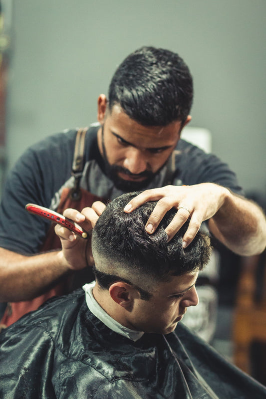 Barberare klipper kund på Little Italy Barbershop