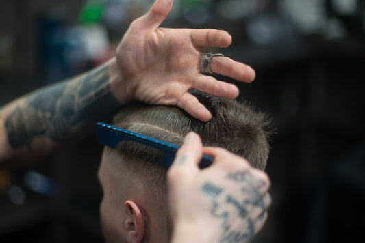 Barberare formar och stylar herrfrisyr med kam
