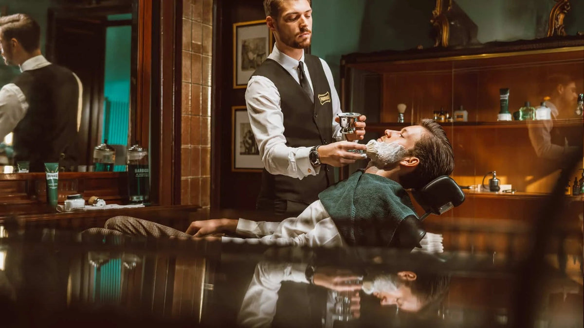 Barber applicerar raklödder på en kund i en Proraso barbershop