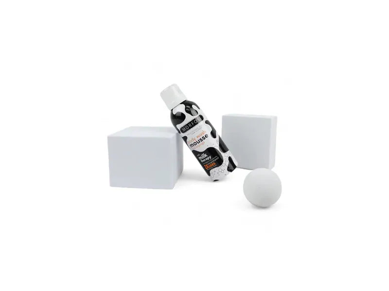 Morfose Milk Therapy Duschgel Mousse 200ml bottle with sleek packaging, surrounded by minimalistic white decor against a plain backdrop.