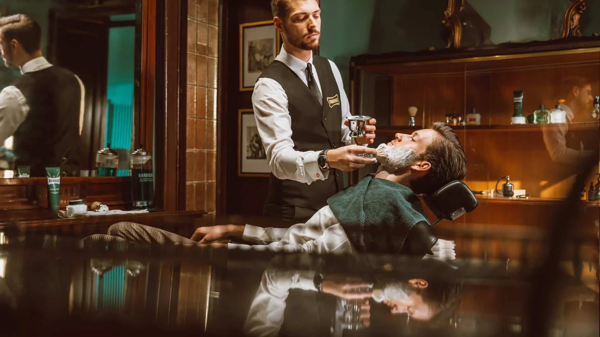 Barber applicerar raklödder på en kund i en Proraso barbershop