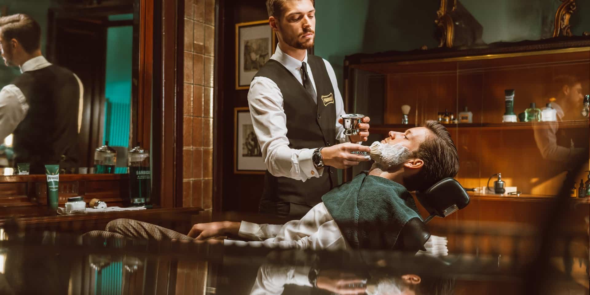 Barber applicerar raklödder på en kund i en Proraso barbershop